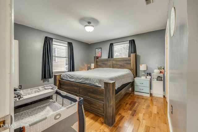 bedroom with light wood-type flooring and multiple windows