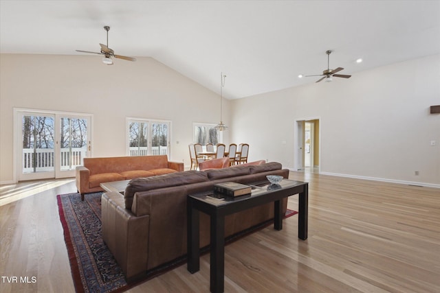 living room featuring hardwood / wood-style flooring, high vaulted ceiling, and ceiling fan