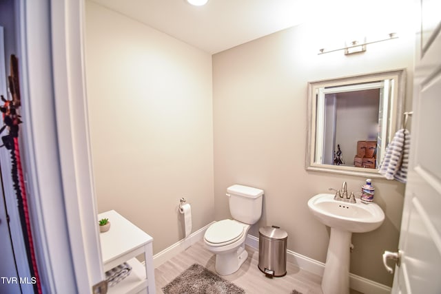 bathroom featuring toilet, sink, and hardwood / wood-style flooring