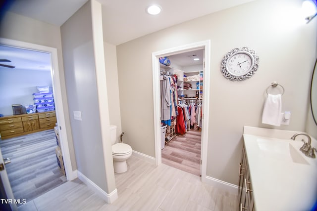 bathroom with toilet, vanity, and hardwood / wood-style floors