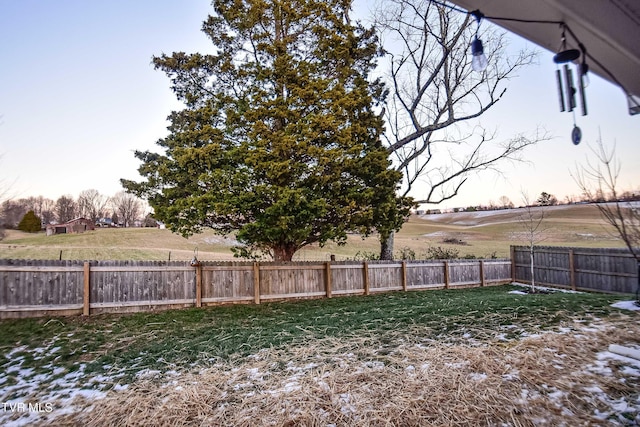 yard at dusk featuring a rural view