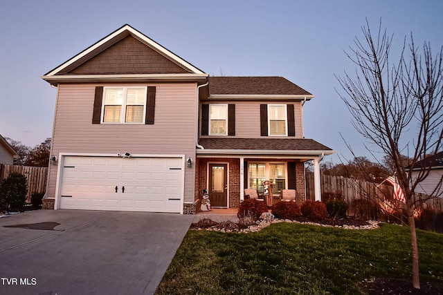 front of property featuring a garage, a porch, and a yard