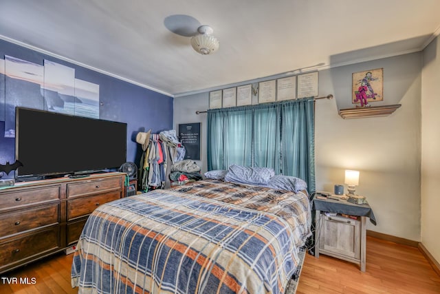 bedroom with hardwood / wood-style floors and ornamental molding