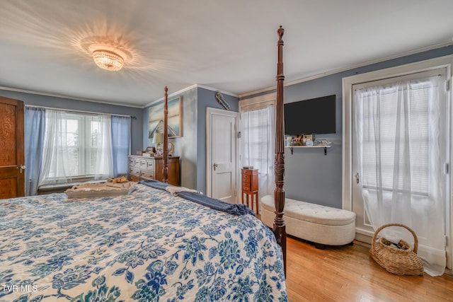 bedroom featuring crown molding and light hardwood / wood-style floors