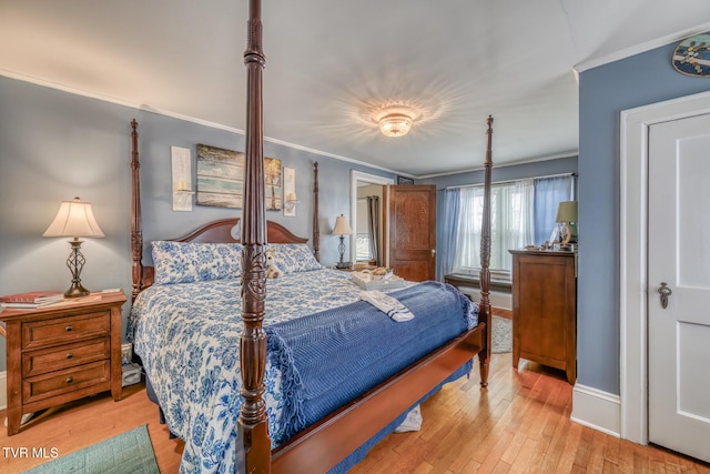 bedroom featuring light wood-type flooring and crown molding