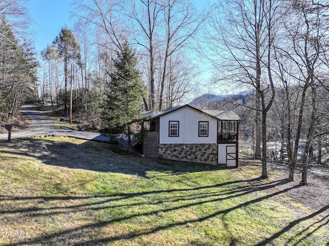 view of side of home featuring a sunroom and a yard