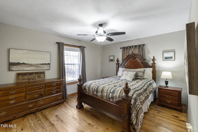 bedroom with ceiling fan, a textured ceiling, and light wood-type flooring