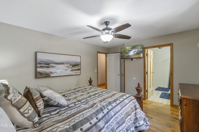 bedroom featuring ceiling fan, ensuite bathroom, and light hardwood / wood-style flooring