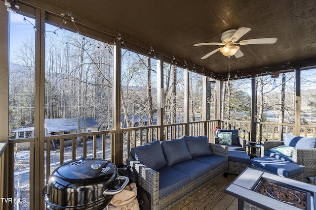 sunroom featuring ceiling fan and wood ceiling