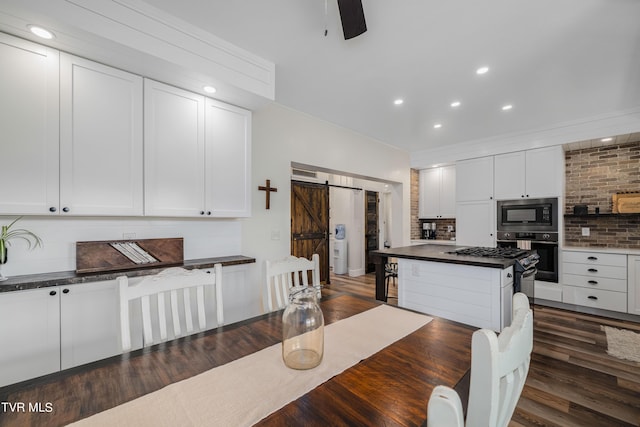 dining space featuring dark hardwood / wood-style flooring and a barn door