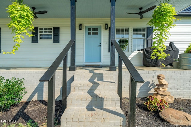 view of exterior entry featuring ceiling fan and a porch