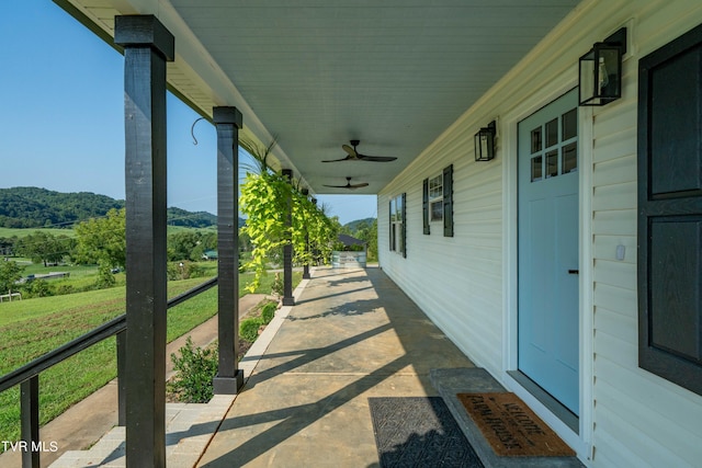 view of patio featuring ceiling fan and a mountain view