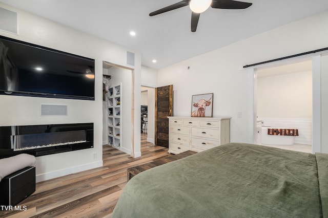 bedroom featuring ensuite bathroom, dark wood-type flooring, and ceiling fan