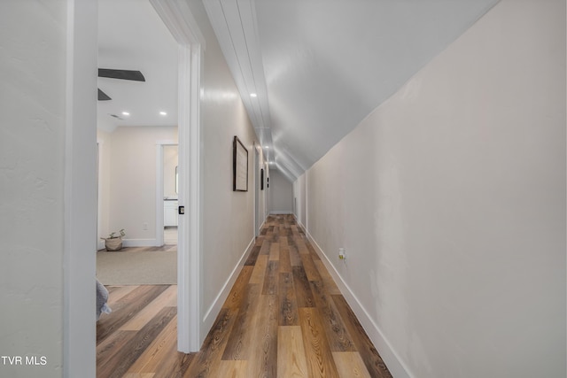 corridor featuring lofted ceiling and hardwood / wood-style floors