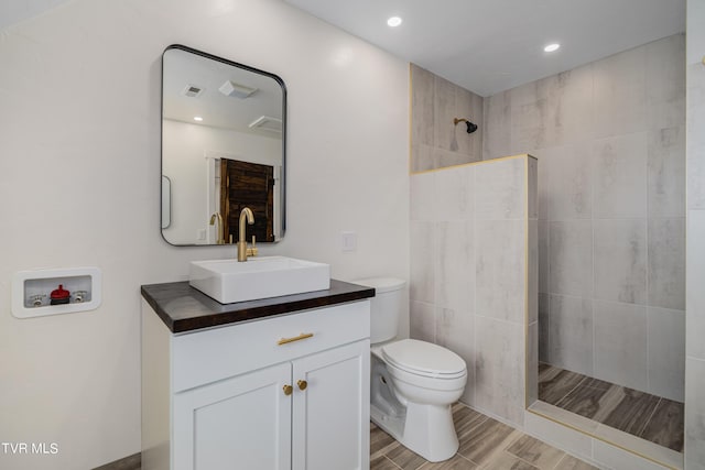 bathroom with toilet, walk in shower, and vanity