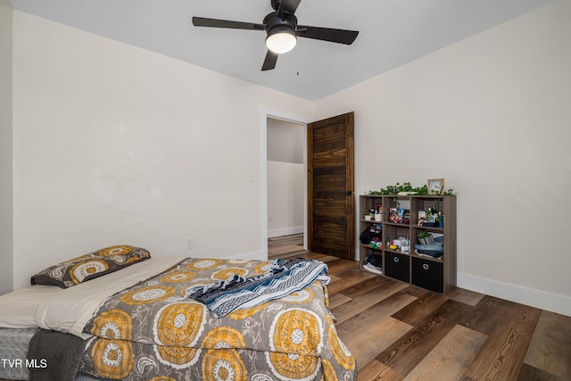 bedroom with ceiling fan and dark wood-type flooring