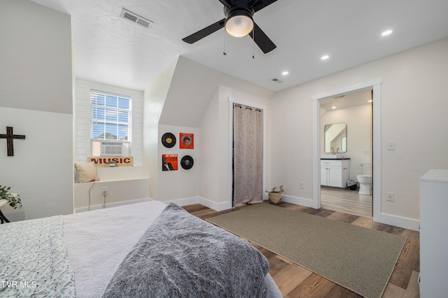 bedroom featuring ensuite bathroom, ceiling fan, cooling unit, and dark hardwood / wood-style flooring