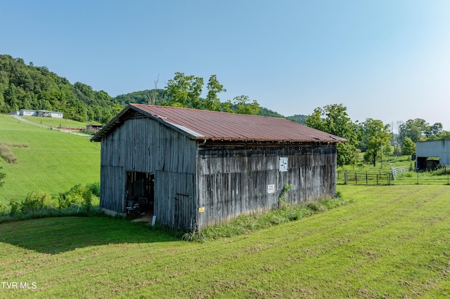 view of outbuilding featuring a yard and a rural view