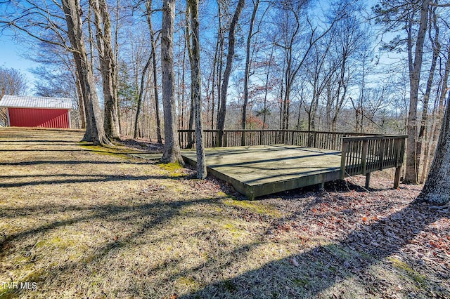 view of yard featuring a wooden deck, an outbuilding, and a pole building