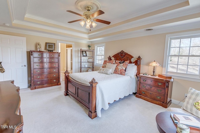 bedroom with a raised ceiling, crown molding, visible vents, and light carpet