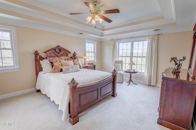 bedroom featuring a raised ceiling, ornamental molding, light colored carpet, and ceiling fan