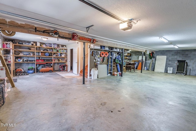 garage featuring a garage door opener and concrete block wall