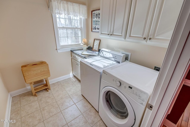 washroom featuring washer and dryer, light tile patterned floors, cabinet space, and baseboards