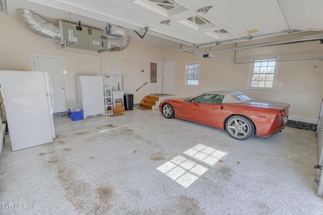 garage with a garage door opener and white fridge