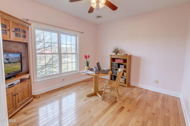 office space with visible vents, baseboards, ceiling fan, and light wood finished floors