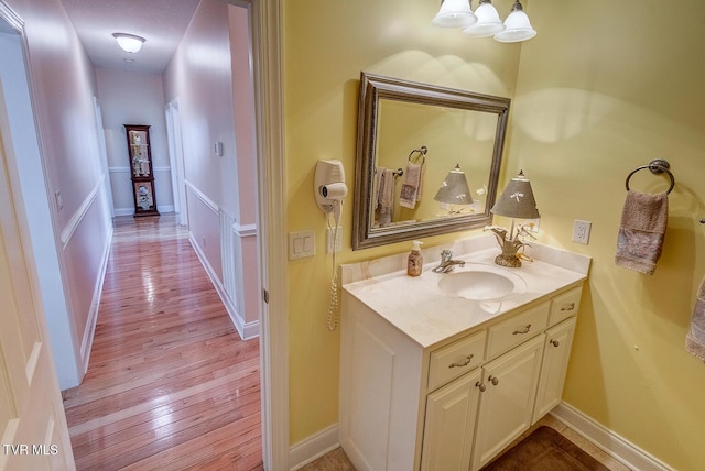 bathroom featuring baseboards, wood finished floors, and vanity