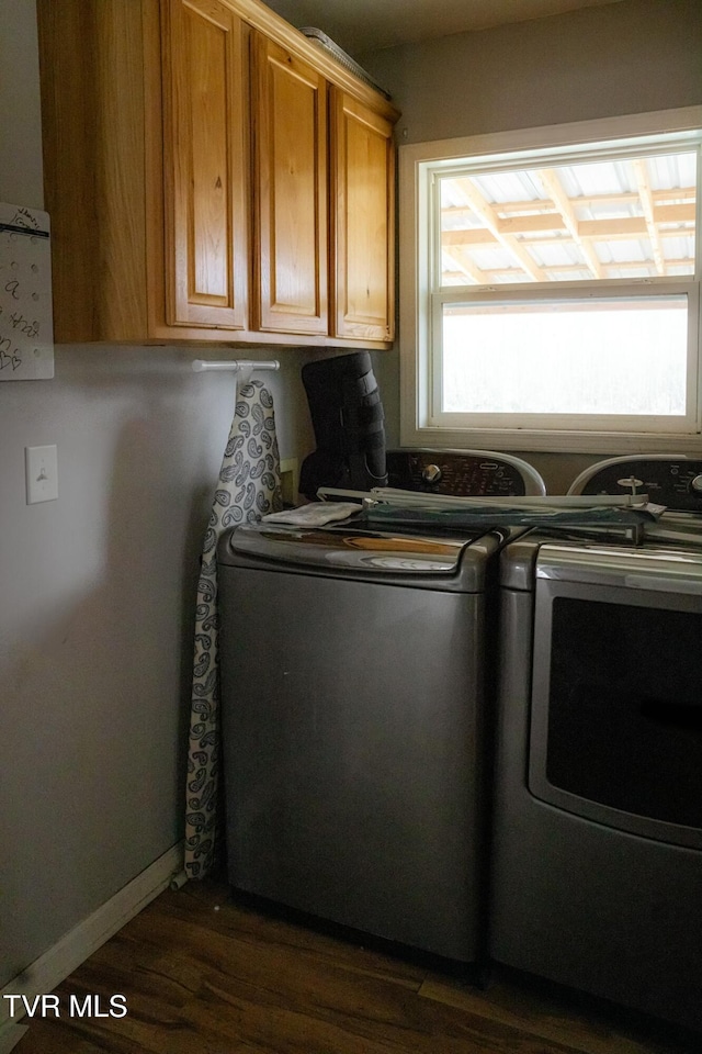 laundry area featuring cabinets, dark wood-type flooring, and washing machine and clothes dryer