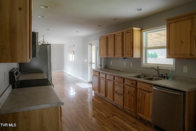 kitchen featuring stainless steel dishwasher, stove, sink, and light hardwood / wood-style flooring