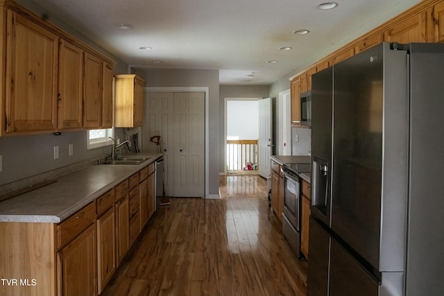 kitchen with sink, appliances with stainless steel finishes, and dark wood-type flooring