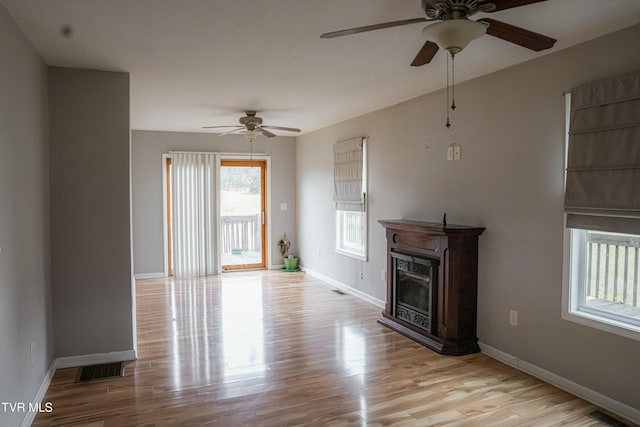 unfurnished living room featuring light wood-type flooring and ceiling fan