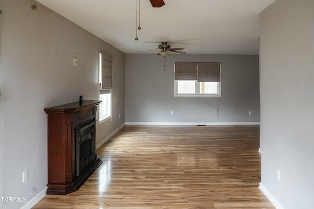 unfurnished living room with ceiling fan and light hardwood / wood-style floors