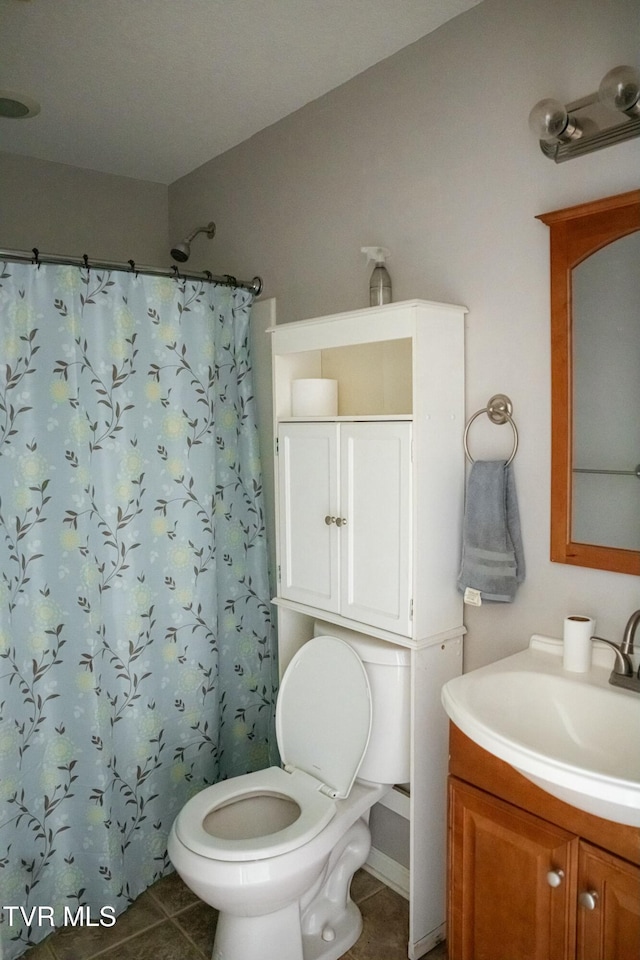 bathroom featuring toilet, vanity, tile patterned floors, and walk in shower