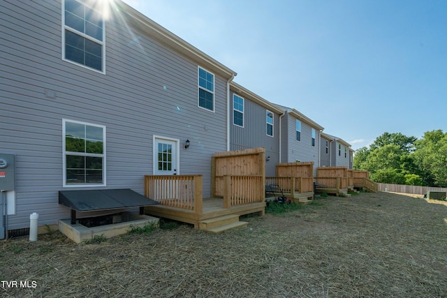 rear view of property with a lawn and a deck