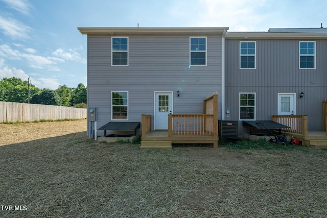 rear view of house featuring a deck and a lawn