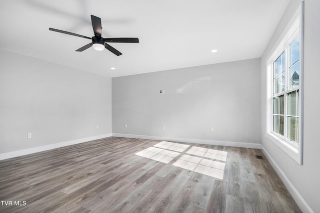 unfurnished room with ceiling fan, a healthy amount of sunlight, and light wood-type flooring