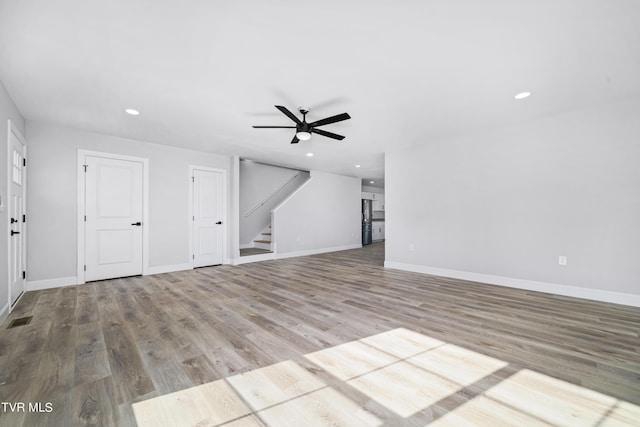 unfurnished living room featuring ceiling fan and light wood-type flooring