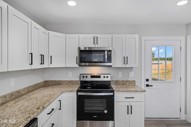 kitchen featuring white cabinets, stainless steel appliances, and light stone countertops