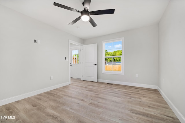 empty room with ceiling fan and light hardwood / wood-style flooring