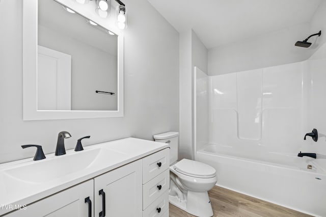 full bathroom featuring bathtub / shower combination, wood-type flooring, vanity, and toilet