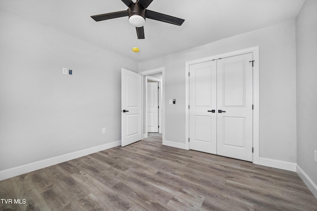 unfurnished bedroom featuring ceiling fan, light wood-type flooring, and a closet