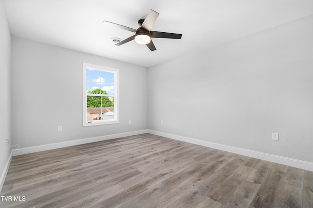 empty room with ceiling fan and light hardwood / wood-style flooring