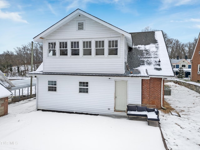 view of snow covered rear of property