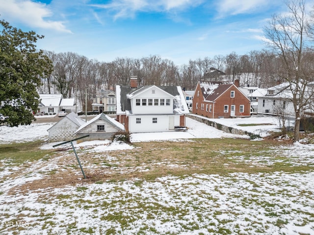 view of snow covered back of property