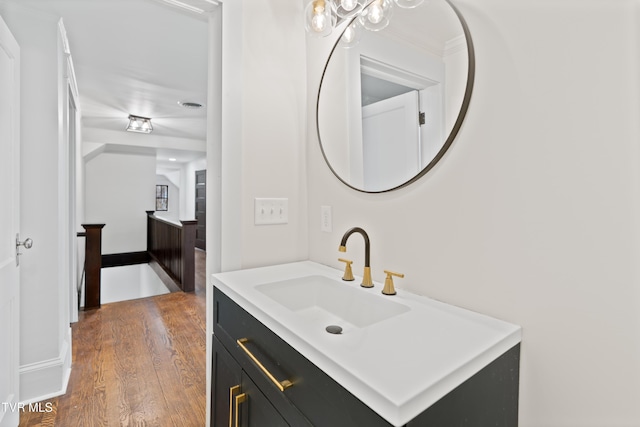 bathroom featuring hardwood / wood-style floors, vanity, and ornamental molding