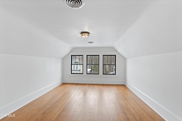 bonus room featuring lofted ceiling and light hardwood / wood-style flooring