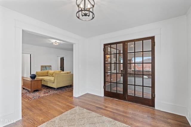 entrance foyer with hardwood / wood-style flooring, ornamental molding, and an inviting chandelier